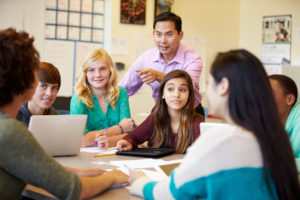 Teacher with students around a table