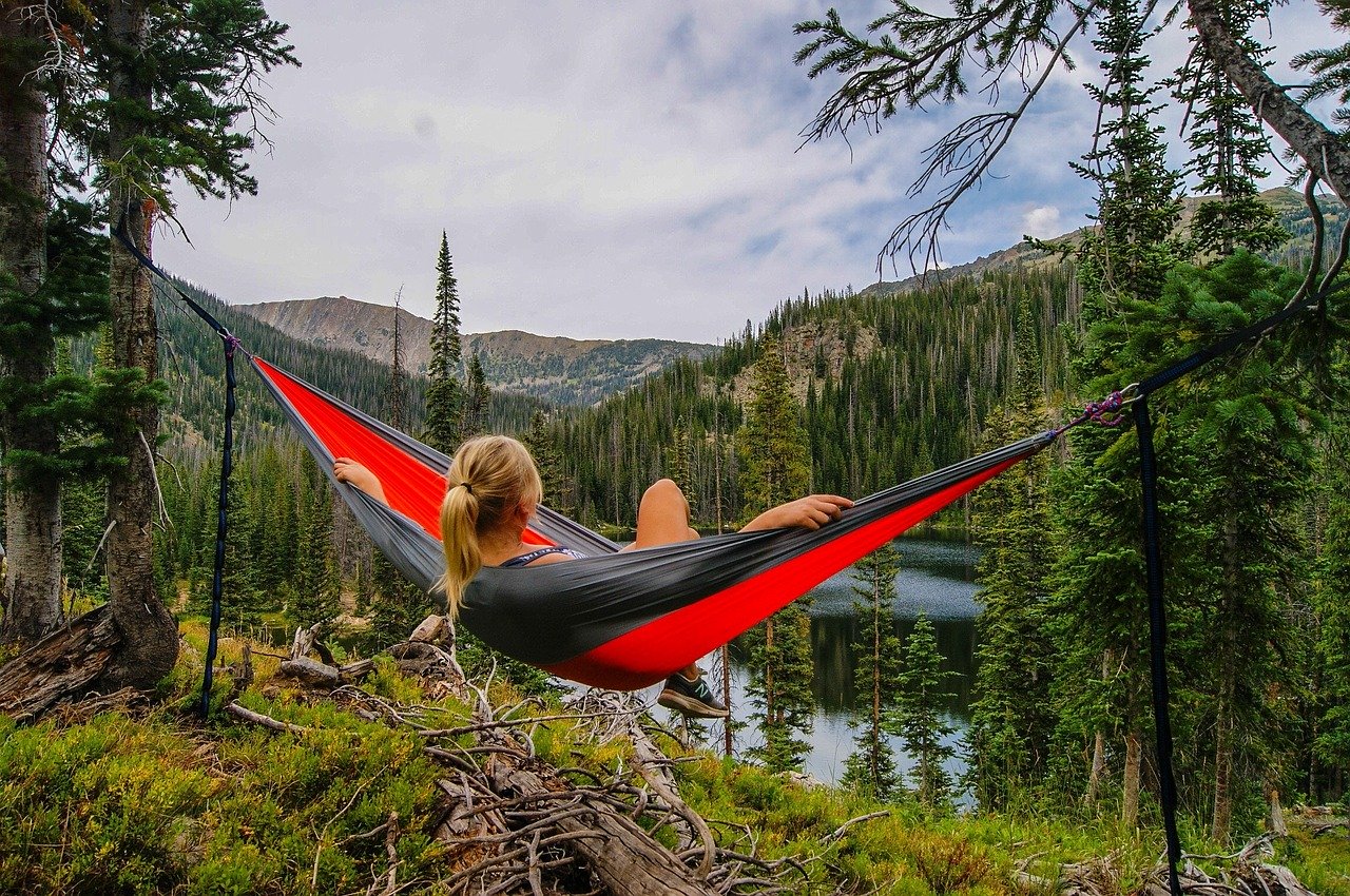 Woman laying in hammock, staring at nature
