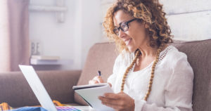 Woman smiling and jotting something in her notebook