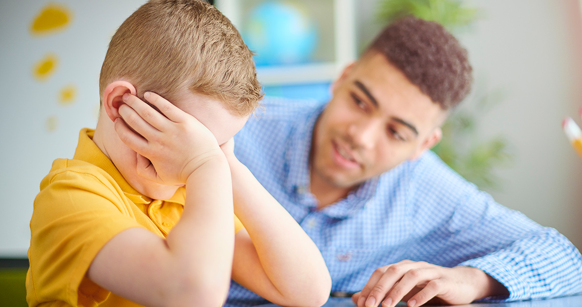 Man comforting a crying boy