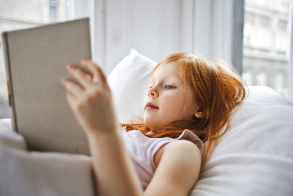 Girl reading book on bed