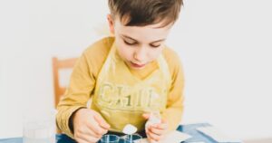 Kid using bottles on kitchen table doing science stuff
