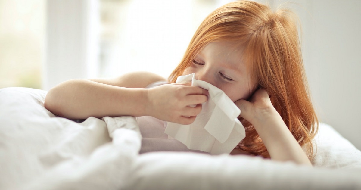 Kid sneezing into tissue