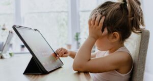 Kid stares and touches at tablet in frustration