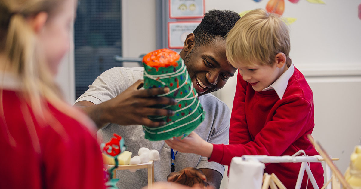 A teacher helping a student with a STEAM project
