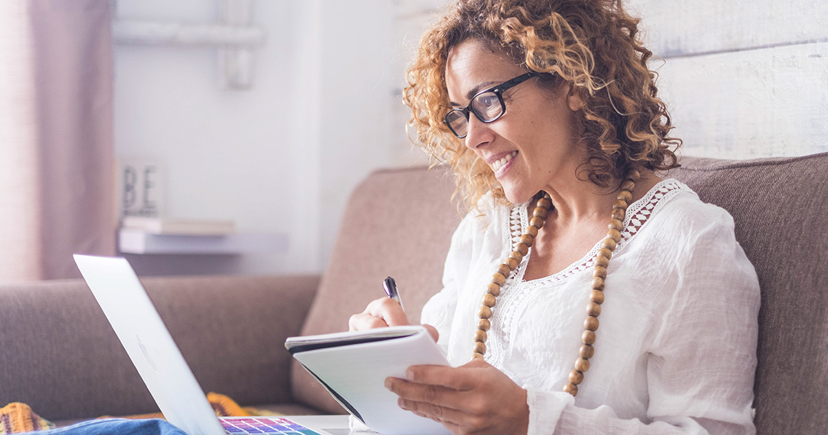 Woman smiling and jotting something in her notebook
