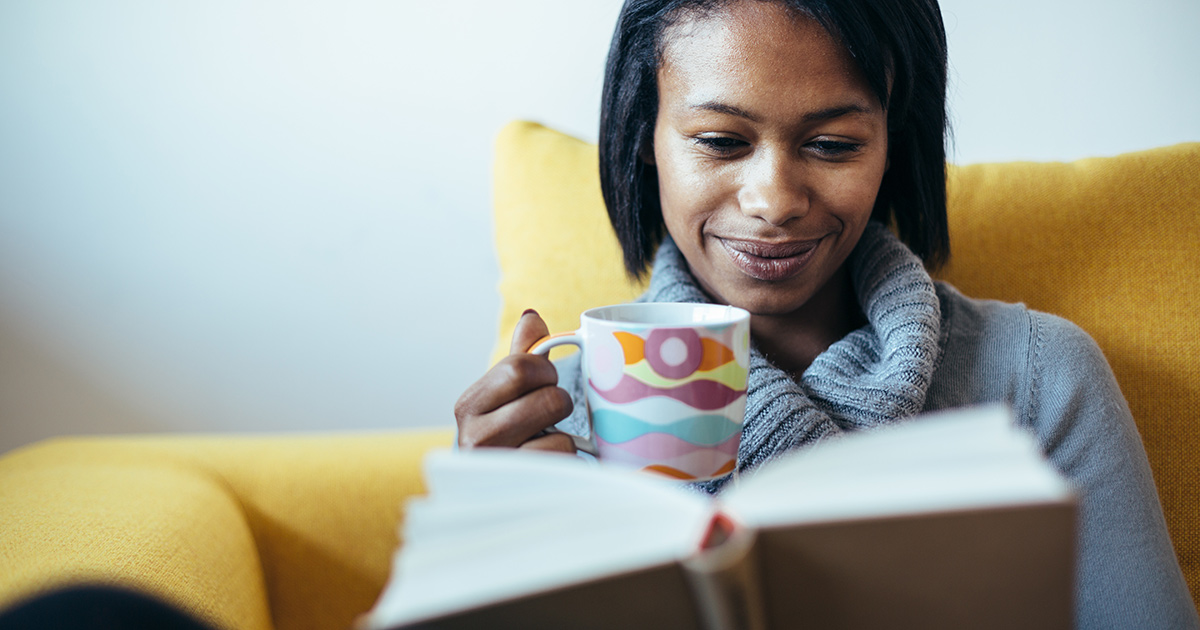 Lady reading a book, holding a cup