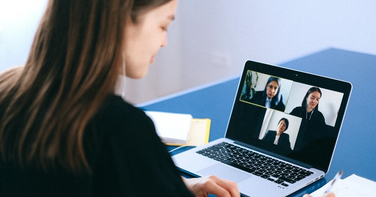 Lady taking notes during a videoconference
