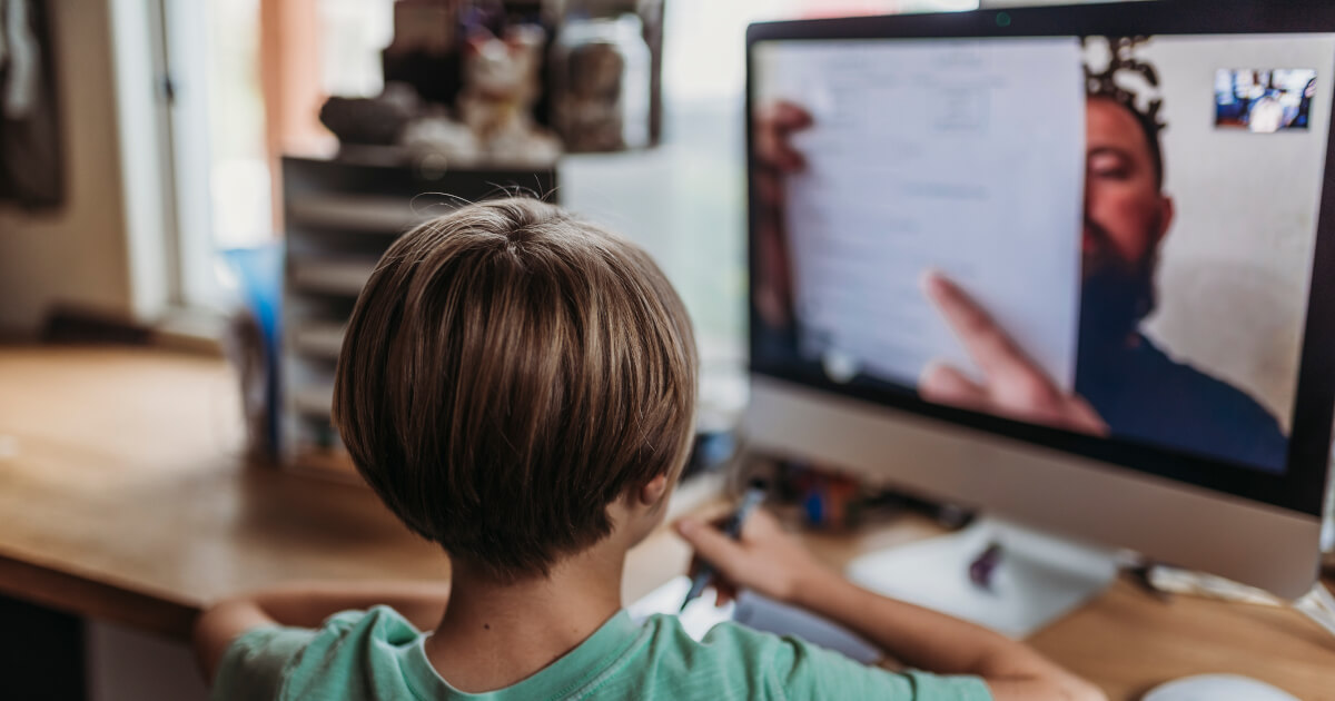 Kid looks at screen with teacher explaining lesson