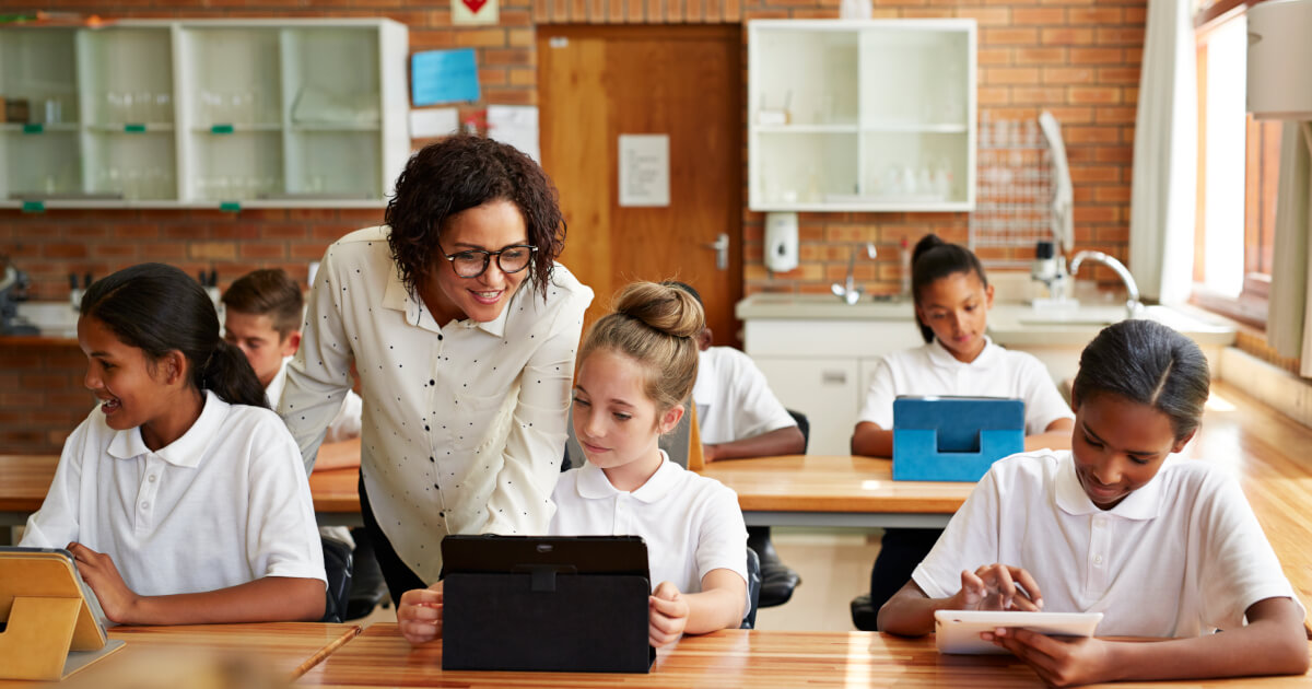 Teacher helping students at their desk